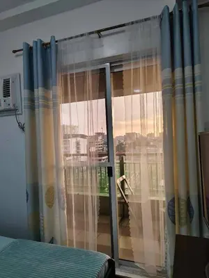 a bedroom with a sliding glass door with a window at Windsong Suite Unli Netflix Disney Roofdeck View in Manila