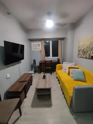 a living room with a yellow couch and a table at 1Bedroom for rent Amaia Skies Shaw in Manila