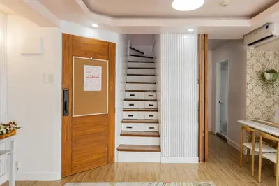 a hallway with a spiral staircase next to a door at Devi Suite 2BR BGC Taguig in Manila