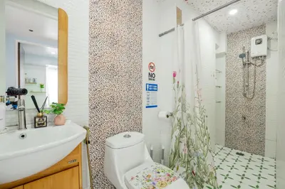 a bathroom with a toilet sink and a shower at Devi Suite 2BR BGC Taguig in Manila