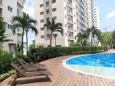 a swimming pool with two chairs next to a building at Casa Solana at SMDC South Residences in Manila