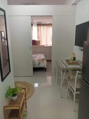 a living room with a kitchen and a table at Casa Solana at SMDC South Residences in Manila