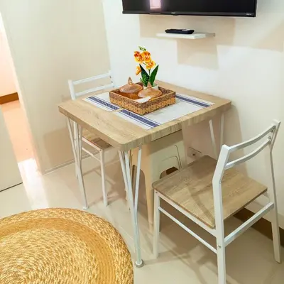 a table with two chairs and a basket of flowers on it at Casa Solana at SMDC South Residences in Manila