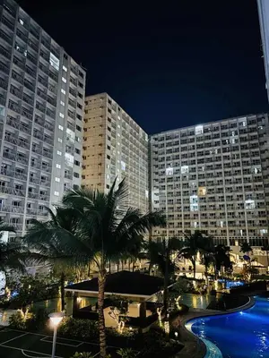 a large building with palm trees in front of it at The C Place Mla in Manila
