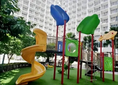 a playground with a slide in a park at The C Place Mla in Manila