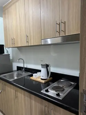 a kitchen with a sink and a stove and cabinets at Metro Prime Stays at Shore 2 Residences in Manila