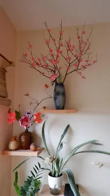 a shelf with a blue vase with flowers on it at Zen Staycation with City and Sunset View near Airport and Mckinley in Manila