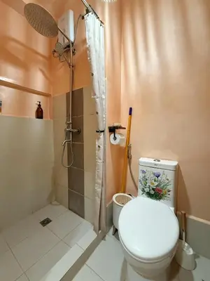 a bathroom with a toilet and a shower at Zen Staycation with City and Sunset View near Airport and Mckinley in Manila