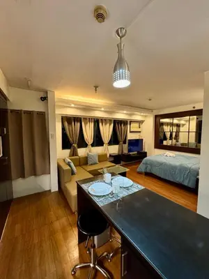 a large living room with a bed and a couch at WestParc Cedar Cozy Apartment in the Heart of Alabang in Manila