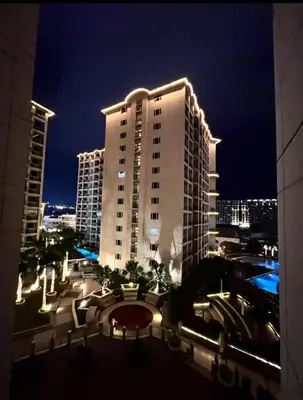 a large white building with lights on it at night at Solemare parksuites in Manila