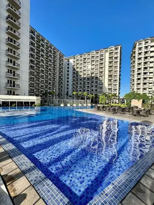 a large swimming pool in front of tall buildings at Solemare parksuites in Manila