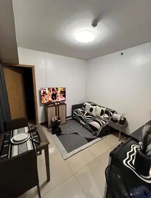 a living room with a couch and a tv at Solemare parksuites in Manila