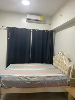a bedroom with a bed with a blue curtain at Shore 2 Tower 1 in Manila
