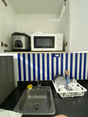 a kitchen counter with a sink and a microwave at Sea Residences Santorini Vibes - Reynil in Manila