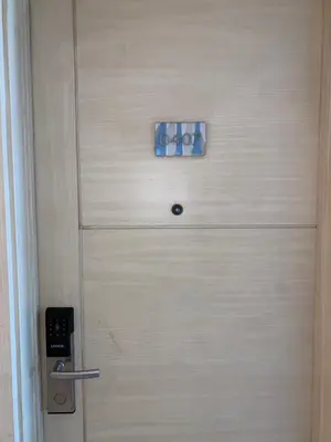 a wooden door with a blue button on it at Sea Residences Santorini Vibes - Reynil in Manila
