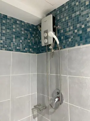 a shower in a bathroom with blue tiles at Sea Residences Santorini Vibes - Reynil in Manila