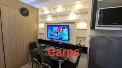 a room with a tv and a table with chairs at Carps Staycation in Manila