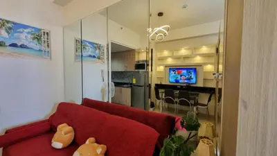 a living room with a red couch and a kitchen at Carps Staycation in Manila
