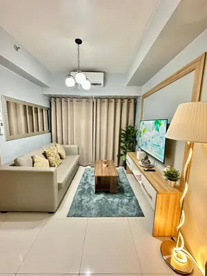 a living room with a couch and a tv at Mall of Asia shore 3 Tower 21661 Residence in Manila