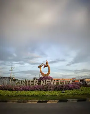 a sign for a faster new city with a statue at Islana Stay Rm A for 1pax only in Imus