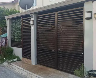 a garage with a wooden gate and a building at Islana Stay Rm A for 1pax only in Imus