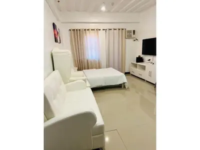 a hotel room with a bed and a tv at Cozy Studio in Paraaque - Perfect for Transients and Long-Stayers Alike in Manila