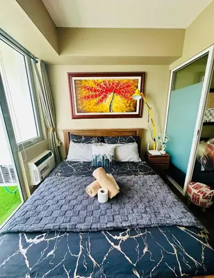 a bedroom with a bed with a teddy bear on it at Condo near airport with PS4 and Parking in Manila