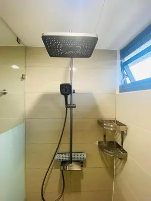 a bathroom with a shower with a light on the ceiling at One Eastwood with mountain view in Manila