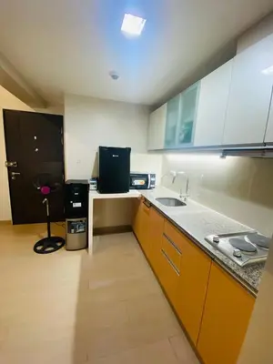 a kitchen with a sink and a counter top at One Eastwood with mountain view in Manila