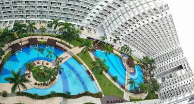 a view of a large building with a pool at Classy and Cozy Staycation near MOA in Manila