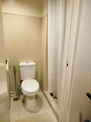 a small bathroom with a toilet and a shower at Classy and Cozy Staycation near MOA in Manila