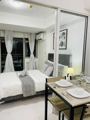 a bedroom with a bed and a table and a dining room at B&T Azure Staycation - Parañaque in Manila