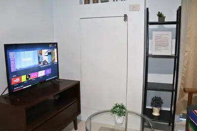 a living room with a flat screen tv on a dresser at Niu Ohana Ortigas Apartments and Residences in Manila