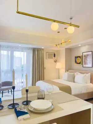 a hotel room with two beds and a table with a dining room at Casa Elisae l Venice Grand Canal Mall Access in Manila