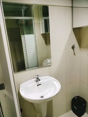 a bathroom with a white sink and a mirror at 349B by Premiere Haven Shell Residences in Manila