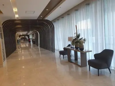 a hallway with a table and chairs in a building at Shore 3 Residences Condo with Netflix and Wifi in Manila