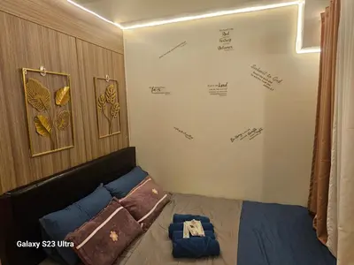 a bedroom with a bed and a wall with signatures at Staycation near MOA, SMX Convention, DFA, NAIA in Manila