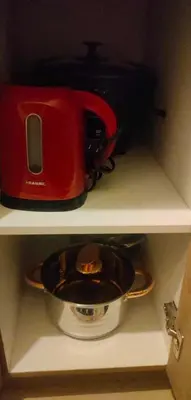 a red toaster sitting on top of a shelf at Staycation near MOA, SMX Convention, DFA, NAIA in Manila