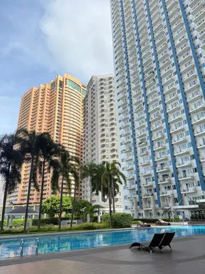 two tall buildings with palm trees in front of them at SMDC Light Residences - Studio Condo Unit in Manila