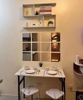 a table with chairs and plates on it in a room at Mars Condo Unit in Manila
