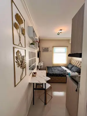 a small room with a bed and a table in it at Mars Condo Unit in Manila