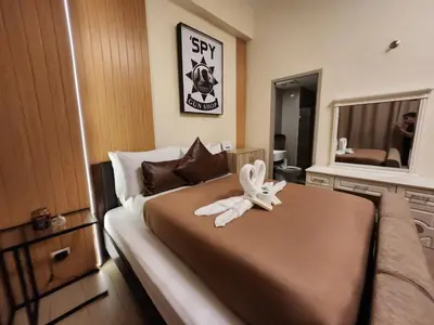 a bedroom with a bed with a white ribbon on it at Two Palm Tree Villas Across NAIA Terminal 3 in Manila