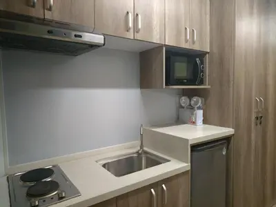 a small kitchen with a sink and a microwave at Sunrise Dormitel in Manila