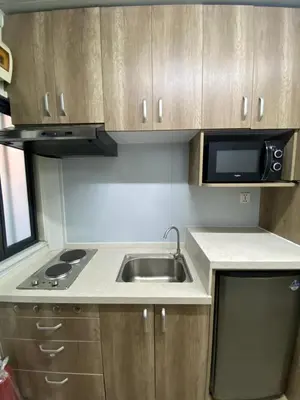 a small kitchen with a sink and a microwave at Sunrise Dormitel in Manila
