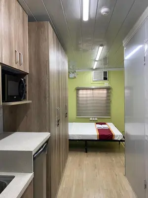 a small kitchen with a bed in a room at Sunrise Dormitel in Manila