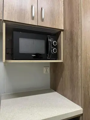 a microwave oven in a kitchen with a counter at Sunrise Dormitel in Manila