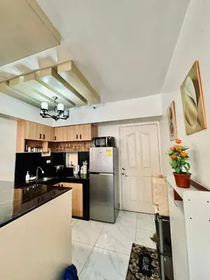 a large kitchen with a stainless steel refrigerator at Condo in Manila in Manila