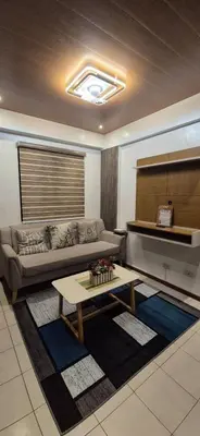 a living room with a couch and a piano at JeweIs Homey Place -2br in a resort-like condo in Manila