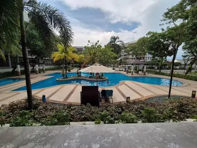 a large swimming pool with an umbrella and palm trees at JeweIs Homey Place -2br in a resort-like condo in Manila