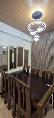 a dining room with a table and chairs and a chandelier at JeweIs Homey Place -2br in a resort-like condo in Manila